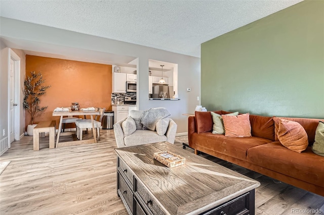 living room featuring light hardwood / wood-style flooring and a textured ceiling