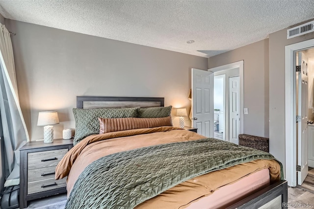 bedroom with hardwood / wood-style flooring and a textured ceiling