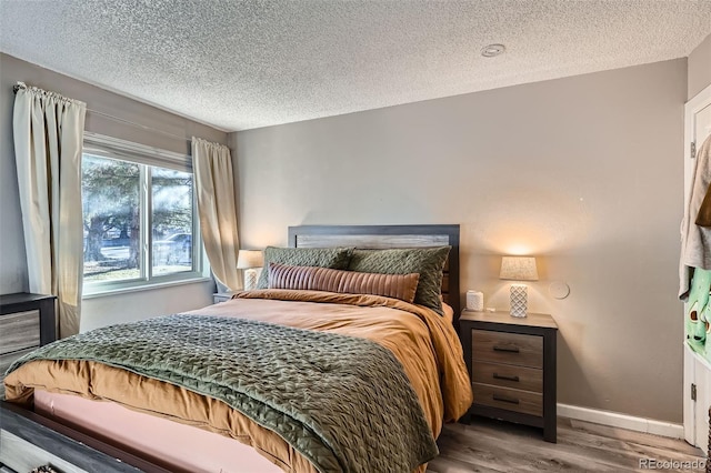 bedroom with wood-type flooring and a textured ceiling