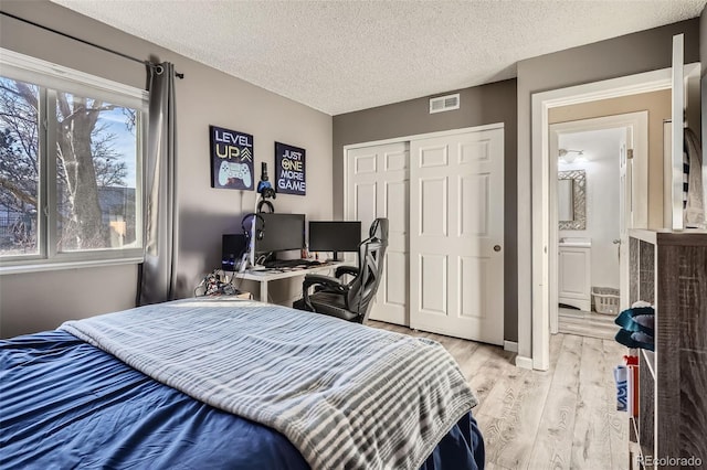 bedroom featuring light hardwood / wood-style flooring, a closet, and a textured ceiling