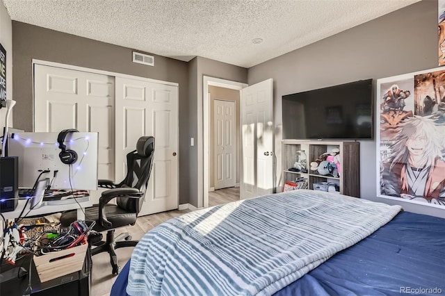 bedroom with light hardwood / wood-style flooring, a closet, and a textured ceiling