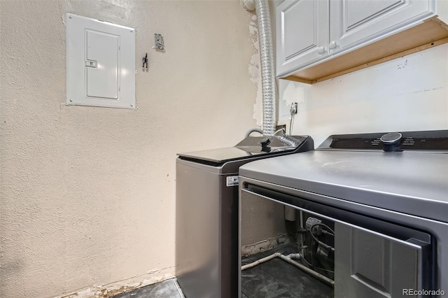 laundry area with cabinets, washing machine and clothes dryer, and electric panel