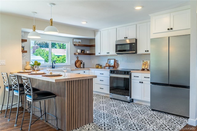 9410 Perry St, Westminster, CO 80031 - kitchen with stainless steel appliances, butcher block counters, open shelves, white cabinetry, and recessed lighting