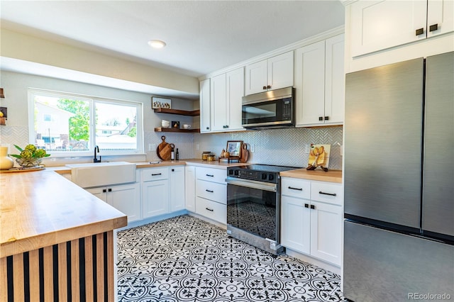 9410 Perry St, Westminster, CO 80031 - kitchen featuring stainless steel appliances, open shelves, backsplash, white cabinets, and butcher block countertops
