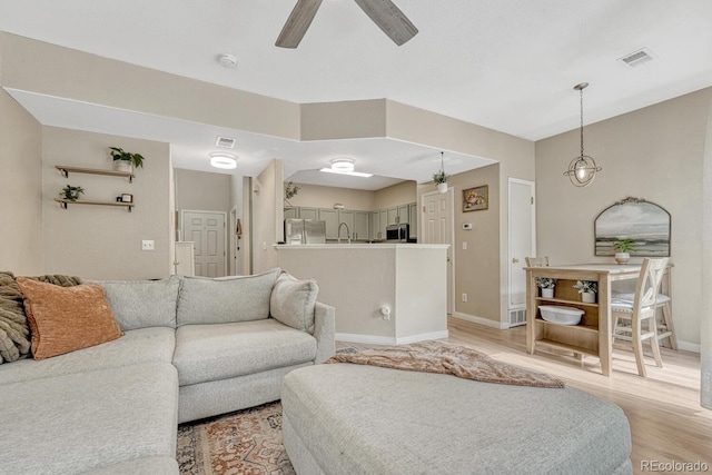 9110 Gale Blvd Unit 3, Thornton, CO 80260 - living area with light wood-style flooring, a ceiling fan, and baseboards
