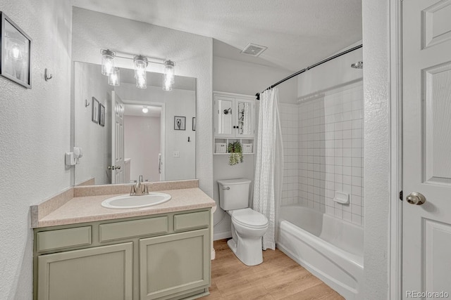 9110 Gale Blvd Unit 3, Thornton, CO 80260 - bathroom featuring a textured wall, toilet, wood finished floors, vanity, and shower / bath combination with curtain