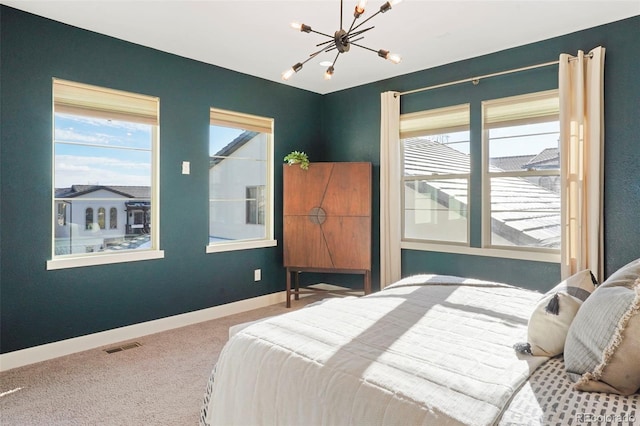 carpeted bedroom featuring a chandelier