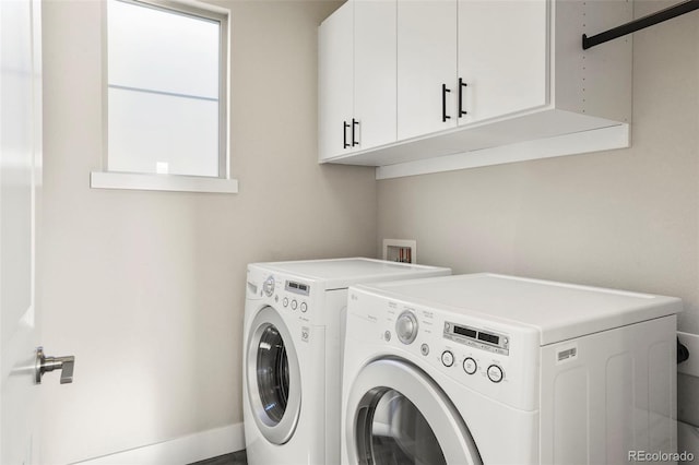 laundry room with washer and dryer and cabinets