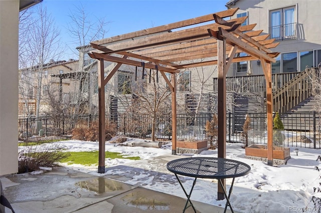 snow covered patio featuring a pergola