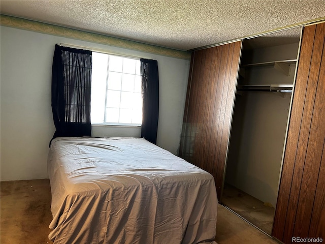 carpeted bedroom with a textured ceiling and a closet