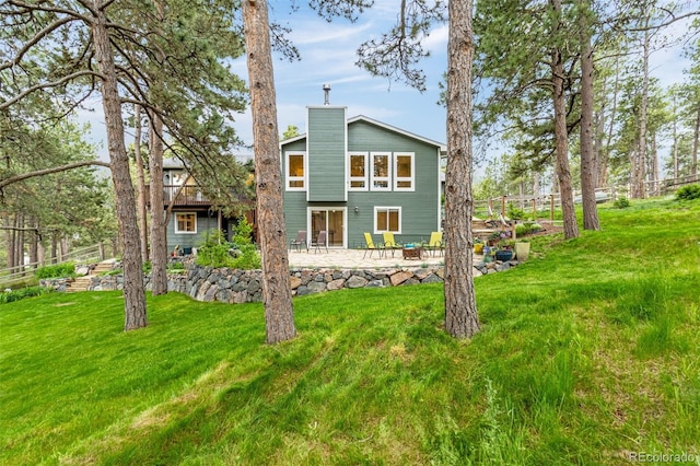 14960 Spiritwood Loop, Elbert, CO 80106 - back of house featuring a chimney, a patio, and a yard