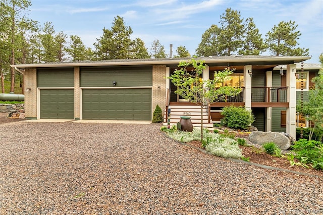 14960 Spiritwood Loop, Elbert, CO 80106 - view of front of property featuring gravel driveway, brick siding, and a garage