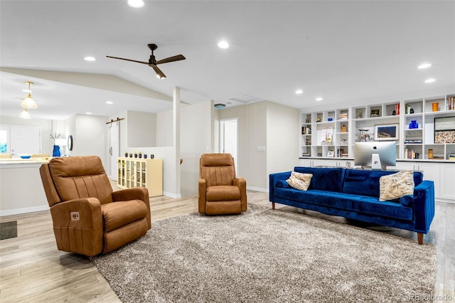 14960 Spiritwood Loop, Elbert, CO 80106 - living room with light wood finished floors, a barn door, ceiling fan, recessed lighting, and vaulted ceiling