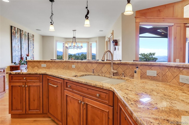 1007 Nob Hill Rd, Evergreen, CO 80439 - kitchen featuring a sink, decorative backsplash, light stone countertops, and brown cabinets