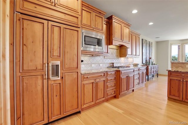 1007 Nob Hill Rd, Evergreen, CO 80439 - kitchen featuring built in appliances, tasteful backsplash, light wood-style flooring, recessed lighting, and light stone countertops