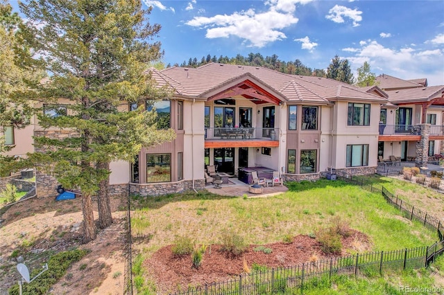 1007 Nob Hill Rd, Evergreen, CO 80439 - back of house with a jacuzzi, stucco siding, a balcony, a tiled roof, and a patio