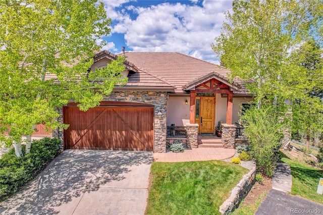 1007 Nob Hill Rd, Evergreen, CO 80439 - view of front of home with a garage, stone siding, driveway, stucco siding, and a tiled roof