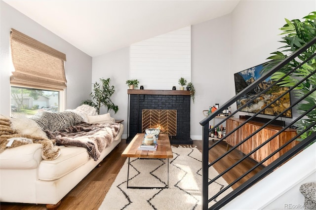 4800 S Tabor St, Morrison, CO 80465 - living room featuring wood finished floors, vaulted ceiling, a brick fireplace, and stairway