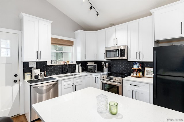 4800 S Tabor St, Morrison, CO 80465 - kitchen with appliances with stainless steel finishes, vaulted ceiling, tasteful backsplash, and light countertops
