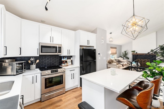 4800 S Tabor St, Morrison, CO 80465 - kitchen with appliances with stainless steel finishes, tasteful backsplash, light wood-style flooring, light countertops, and white cabinets