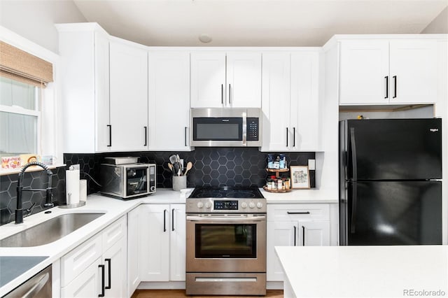 4800 S Tabor St, Morrison, CO 80465 - kitchen featuring stainless steel appliances, white cabinetry, decorative backsplash, and light countertops