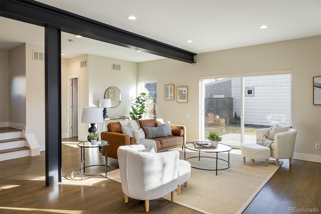 living room featuring beam ceiling and dark hardwood / wood-style floors