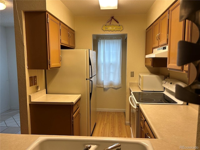 kitchen featuring white appliances and light hardwood / wood-style flooring