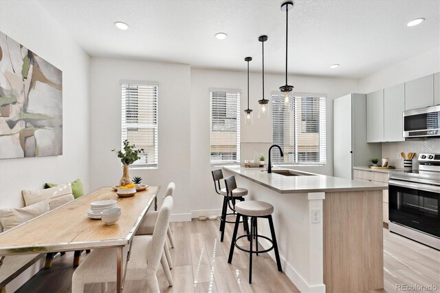 5128 W 26th Ave Unit 312, Denver, CO 80212 - kitchen featuring stainless steel appliances, decorative backsplash, light countertops, recessed lighting, and plenty of natural light