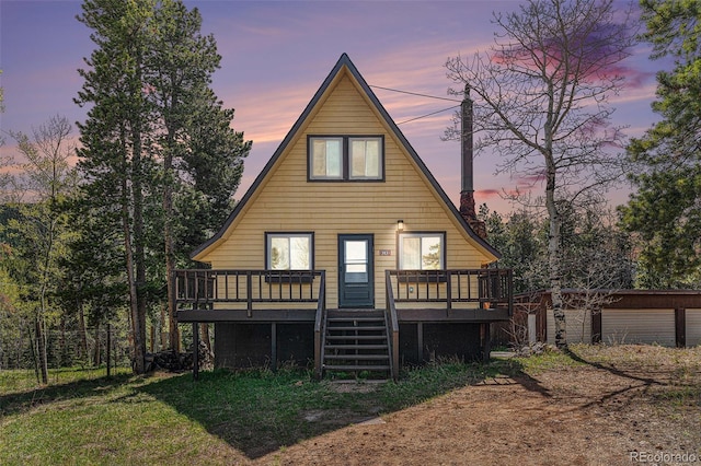 9185 Jill Dr, Conifer, CO 80433 - rear view of house featuring a wooden deck, stairway, and a chimney