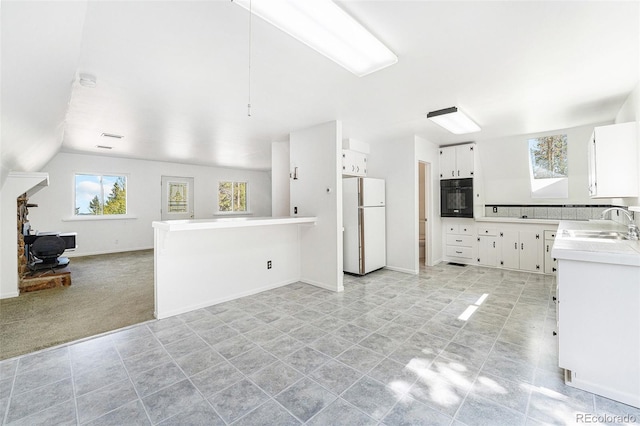 9185 Jill Dr, Conifer, CO 80433 - kitchen with freestanding refrigerator, oven, a sink, open floor plan, and white cabinetry