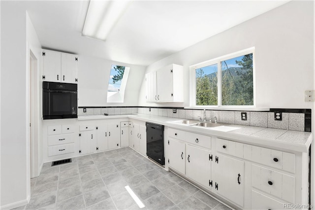 9185 Jill Dr, Conifer, CO 80433 - kitchen with black appliances, a skylight, light countertops, and white cabinets