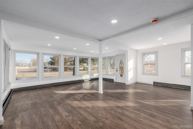 interior space featuring a textured ceiling, dark hardwood / wood-style floors, and a baseboard heating unit