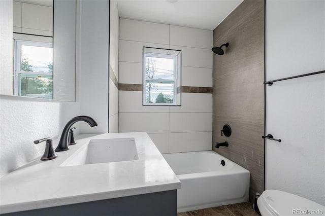 full bathroom featuring vanity, tiled shower / bath combo, and toilet