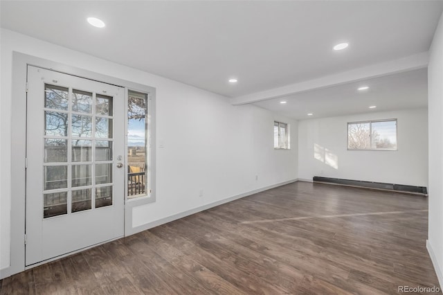 empty room featuring dark hardwood / wood-style flooring and baseboard heating