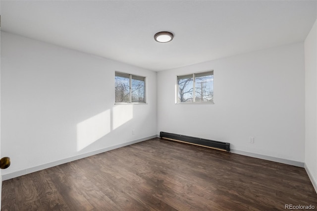 spare room featuring dark hardwood / wood-style flooring and a baseboard radiator