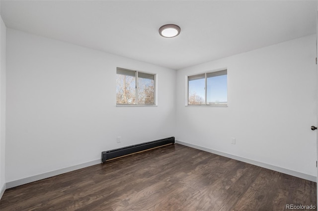 unfurnished room featuring a baseboard radiator and dark hardwood / wood-style floors