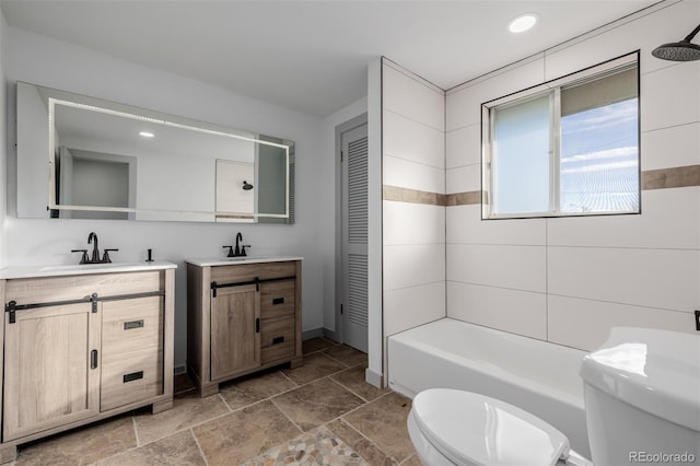 full bathroom featuring vanity, tiled shower / bath combo, and toilet