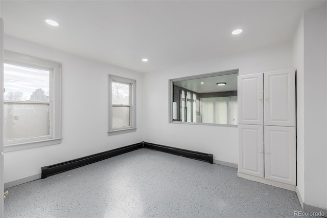 spare room featuring a baseboard radiator and a wealth of natural light