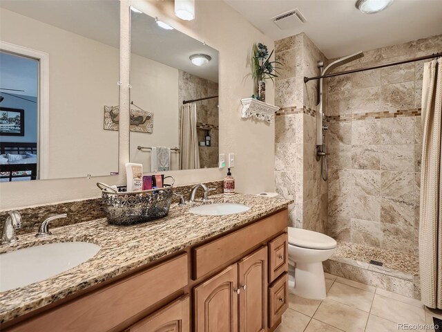 3265 W 11th Avenue Ct, Broomfield, CO 80020 - full bathroom featuring a tile shower, double vanity, toilet, and tile patterned floors