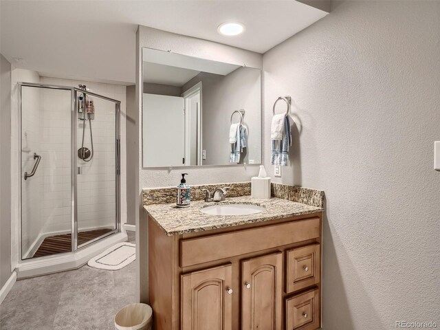 3265 W 11th Avenue Ct, Broomfield, CO 80020 - bathroom featuring a shower stall, vanity, a textured wall, and baseboards