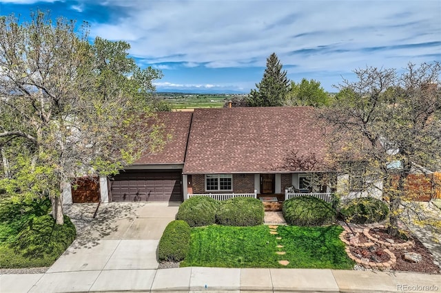 3265 W 11th Avenue Ct, Broomfield, CO 80020 - view of front of house featuring a porch, driveway, brick siding, a garage, and roof with shingles