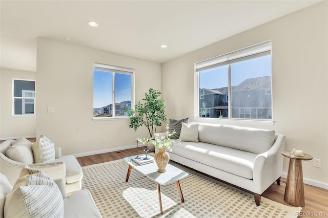living room featuring wood finished floors, baseboards, and recessed lighting
