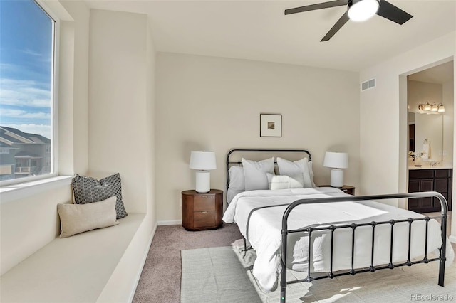 bedroom featuring visible vents, a ceiling fan, carpet flooring, and ensuite bath