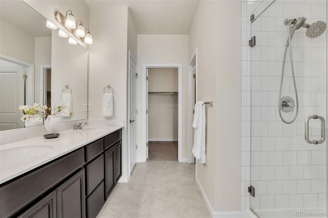 full bath with a spacious closet, tiled shower, a sink, and tile patterned flooring