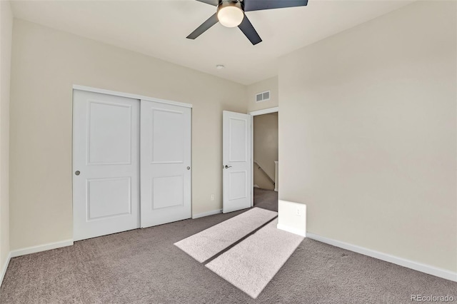 unfurnished bedroom featuring carpet flooring, visible vents, a closet, and baseboards
