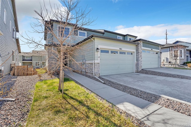 view of front facade with fence, a garage, stone siding, and driveway