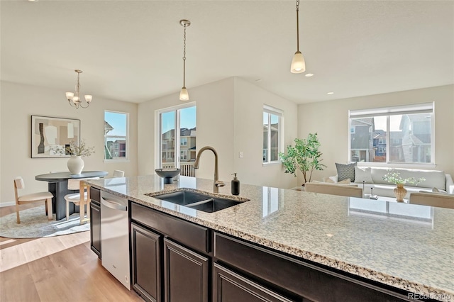 kitchen featuring dark brown cabinets, a chandelier, dishwasher, a sink, and light wood finished floors