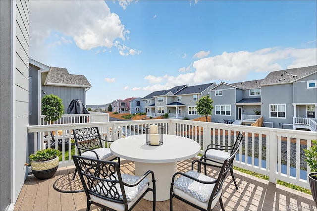 wooden terrace featuring outdoor dining space and a residential view