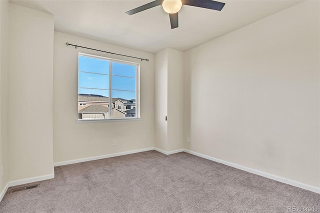 empty room featuring carpet, visible vents, baseboards, and ceiling fan