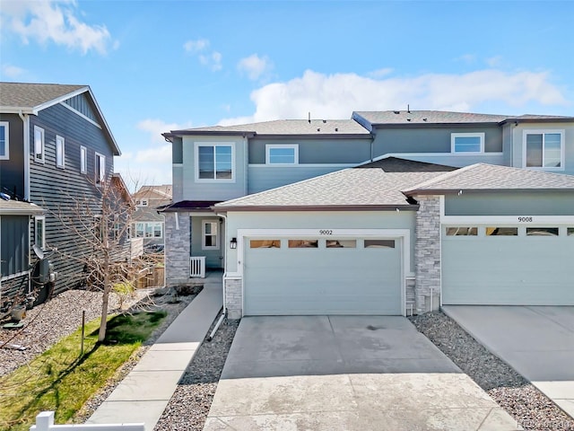 view of front of home featuring a garage, stucco siding, stone siding, a shingled roof, and concrete driveway